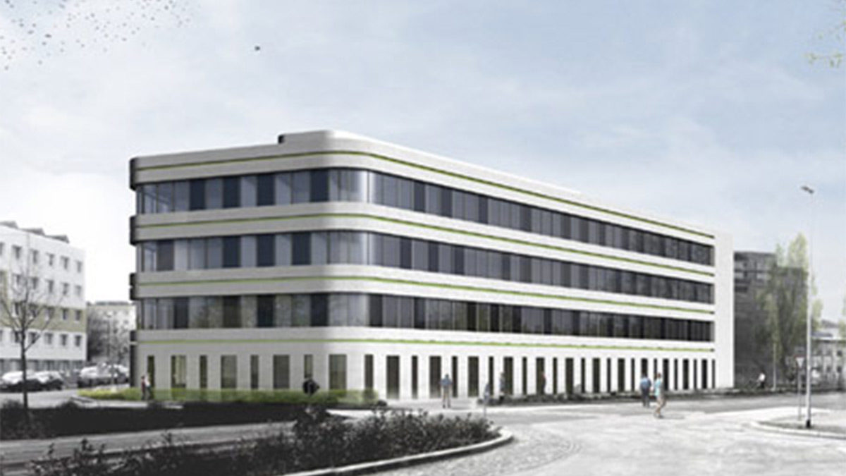 Ein modernes, vierstöckiges Bürogebäude mit Glasfenstern und abgerundeten Ecken steht an einer Straßenkreuzung unter einem leicht bewölkten Himmel.