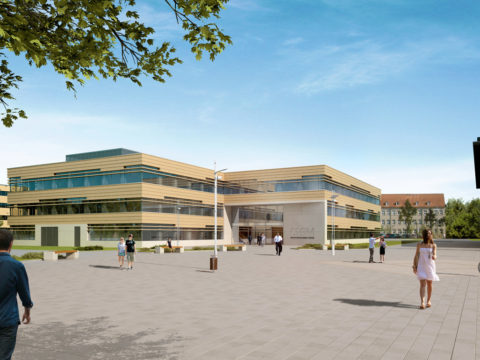 Modernes Bildungsgebäude mit großen Fenstern, umgeben von Spaziergängern, Radfahrern und Menschen, die in einem großen gepflasterten Innenhof unter blauem Himmel sitzen.