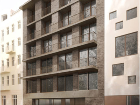 Modernes mittelgroßes Wohnhaus mit Backsteinfassade, großen Fenstern und Balkonen, das zwischen zwei älteren Gebäuden liegt, mit einem unscharfen Auto, das davor vorbeifährt.