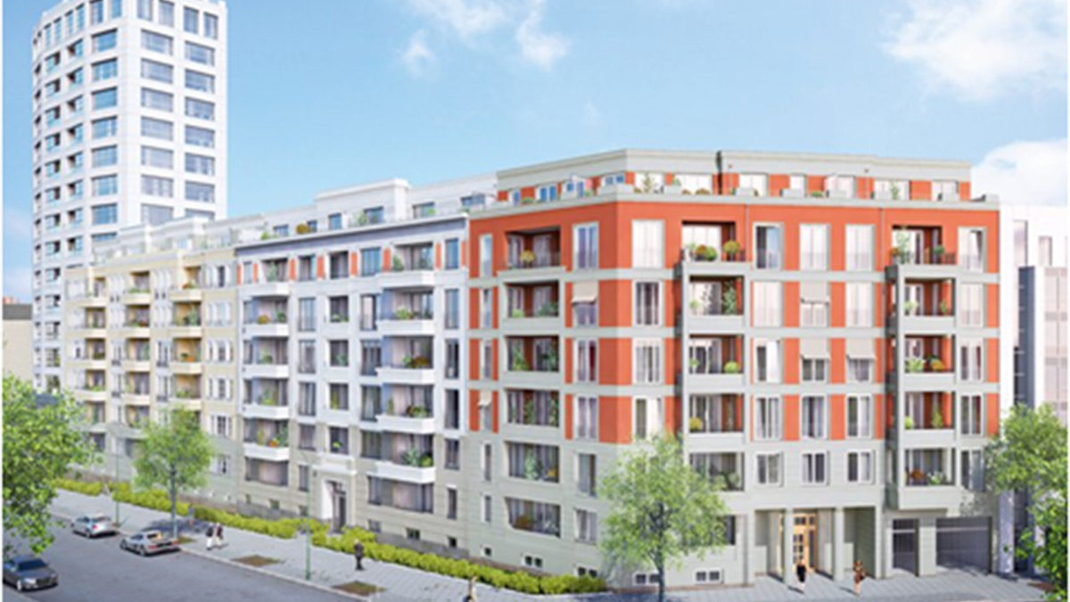 Modernes mehrstöckiges Wohngebäude mit orangefarbener und weißer Fassade, Balkonen und Straßenansicht, mit einem höheren weißen Gebäude im Hintergrund unter klarem Himmel.